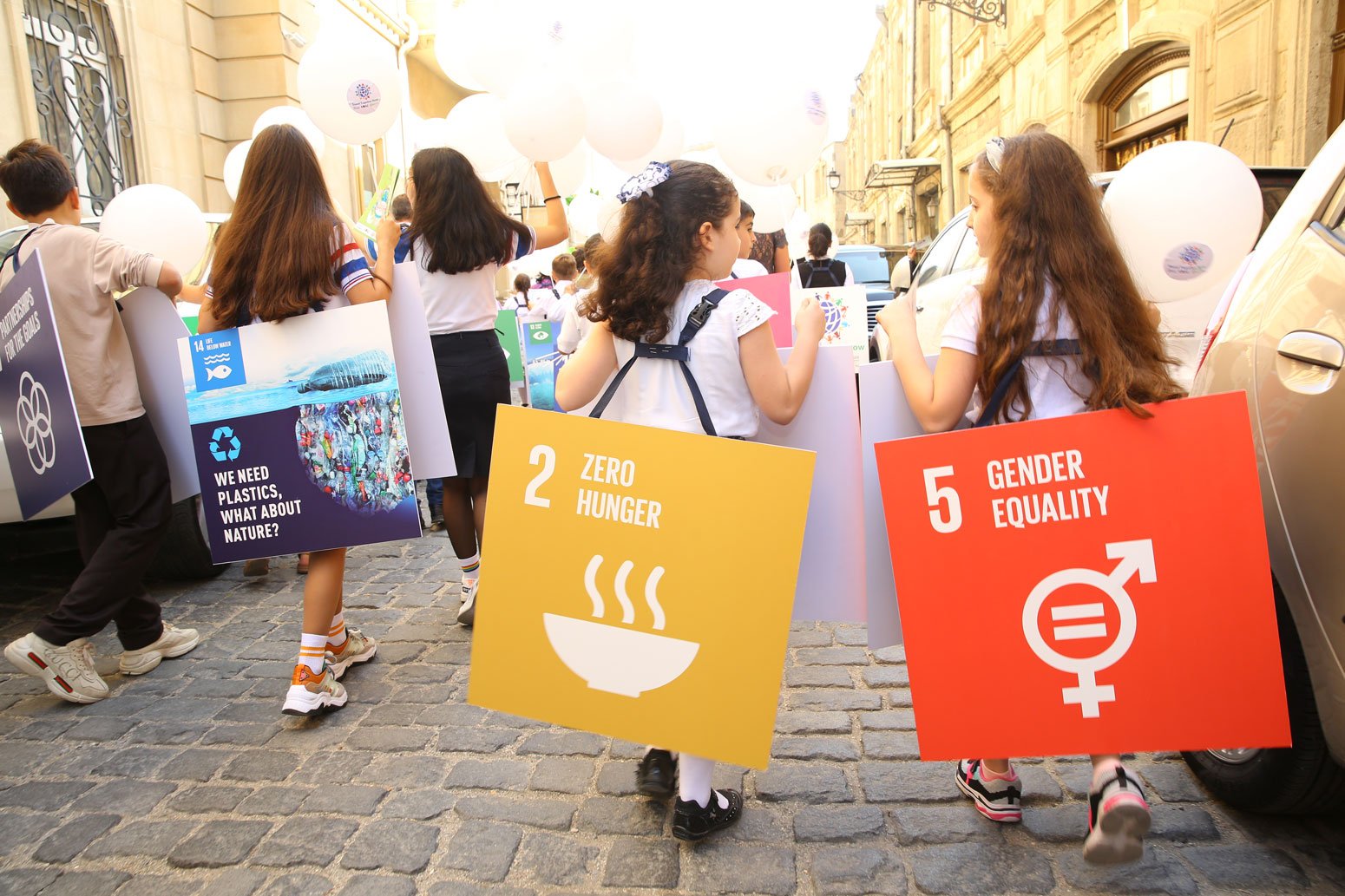 Children march with sustainable development goal placards © Adil Celebiyev StokPhoto