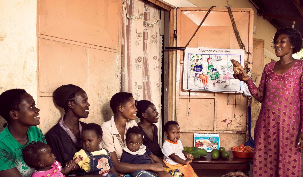 A community health promoter teaches mothers with small children about nutrition at her home hear Mityebili, Uganda. © Stephan Gladieu/World Bank