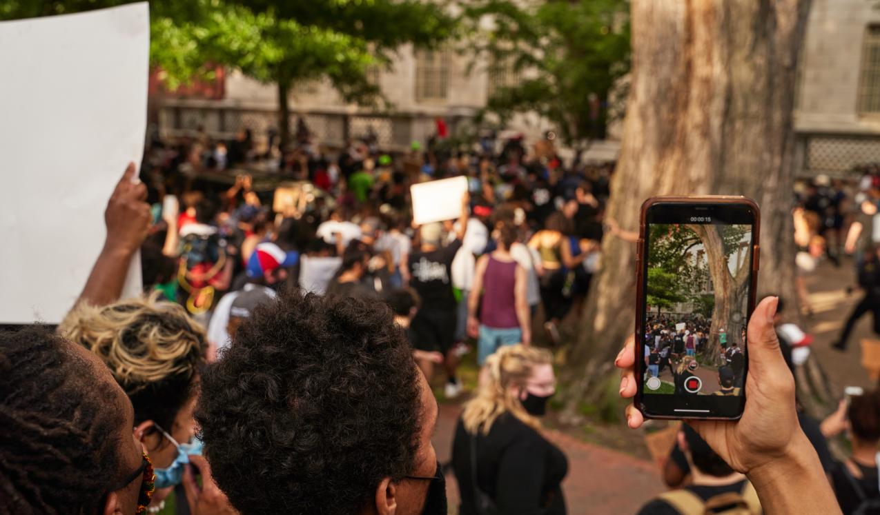 A person records protesters with their phone in Washington, DC / United States. © Jackson Fox-Bland/shutterstock