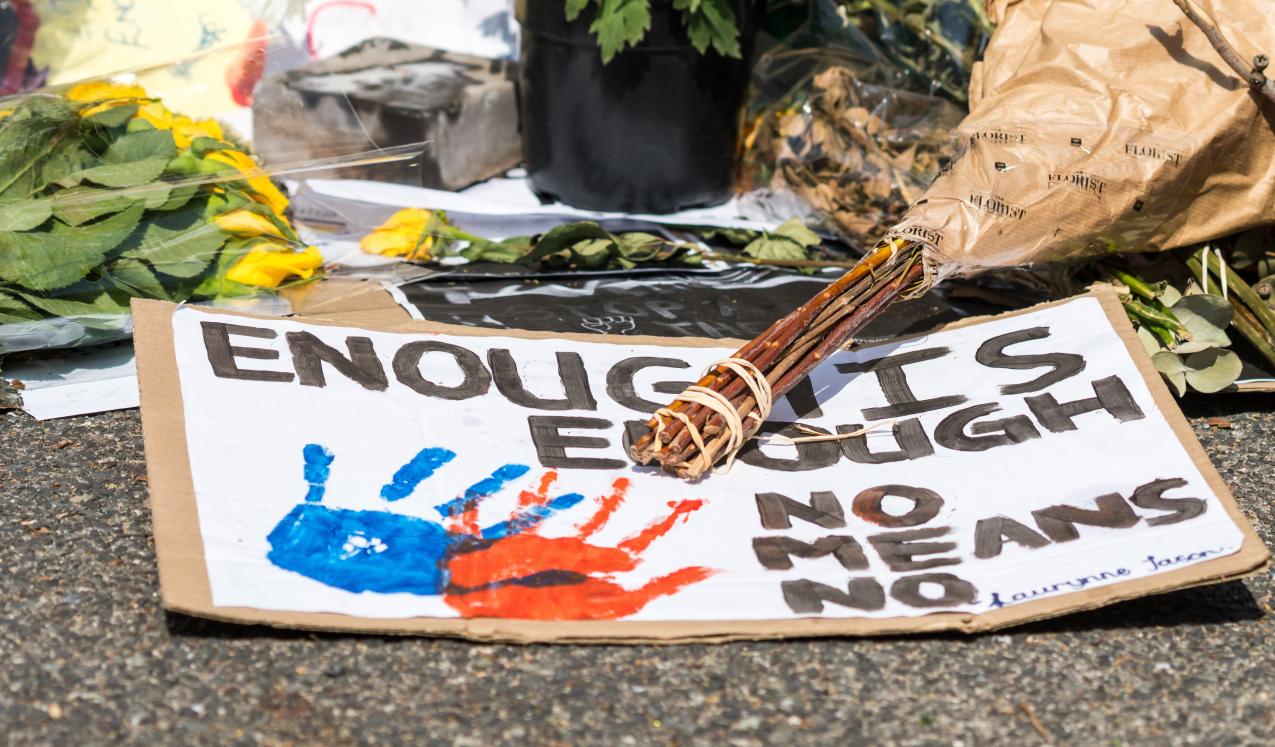 Sign and flowers at a shrine for a woman who was raped and murdered in Cape Town, South Africa. © Roxane 134 | Shutterstock ID: 2208321545