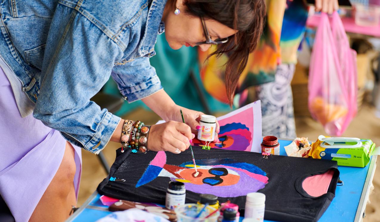 A Russian artist painting a motif on a black tshirt© travelarium.ph | Shutterstock ID: 2064241469