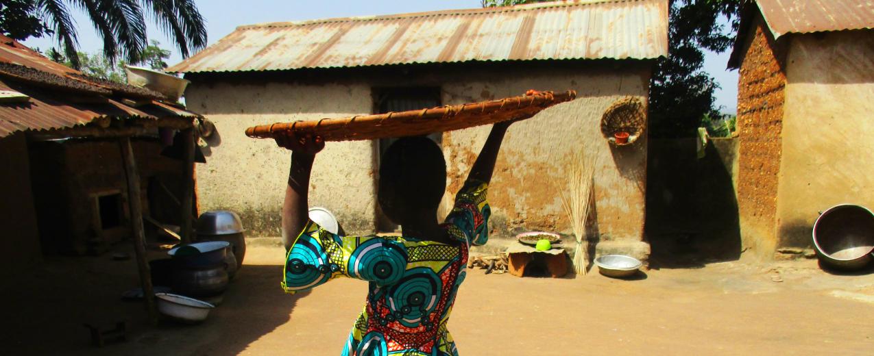 A lady carrying a large flat basket on her head. Credit: Plan International Togo