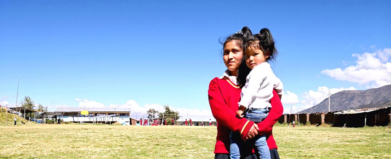 A schoolgirl holds her younger sister. Credit: Visionaria