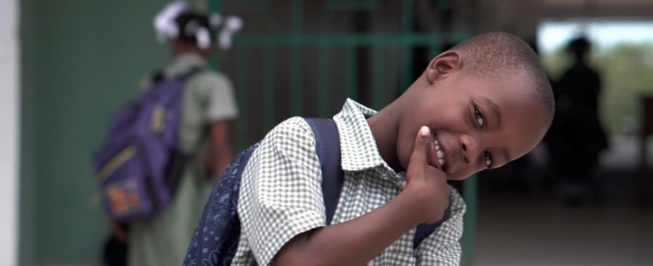 A school boy smiling for the camera. © Zach Vessels