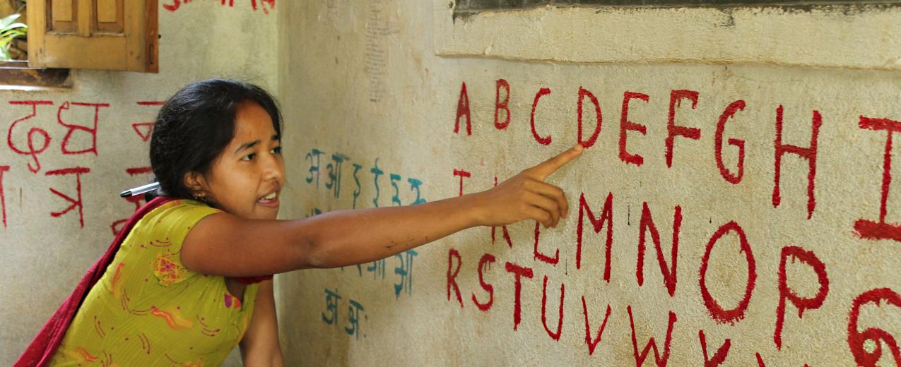 A teach in rural Nepal points to letters as she teaches her class how to read the English alphabet. © Aisha Faquir/World Bank