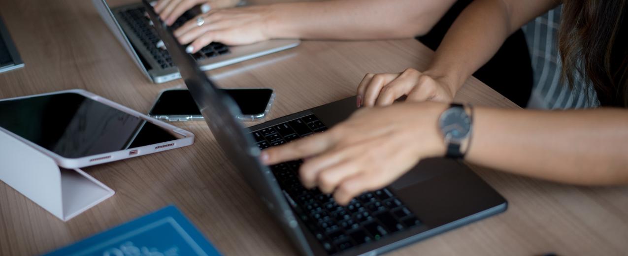 A close up of two laptops with hands working on them. © UN Women/Ploy Phutpheng/DSC_4884