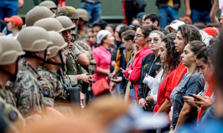 Female protesters stand in a line before Lebanese army soldiers during a demonstration on the seventh day of unrest against tax increases and official corruption, in Zouk Mosbeh, north of Beirut. © AFP