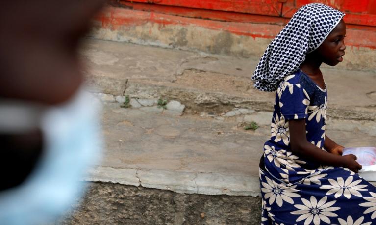 A girl sits after receiving goods from volunteers during food and water distribution to the underprivileged and homeless, as Ghana enforces a partial lockdown in Accra and Kumasi in efforts to slow the spread of the coronavirus disease (COVID-19), in Accra, Ghana. April 4, 2020. REUTERS/Francis Kokoroko