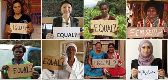 Women holding placards with the word EQUAL on them