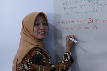 A participant writes notes on a white board at the convening